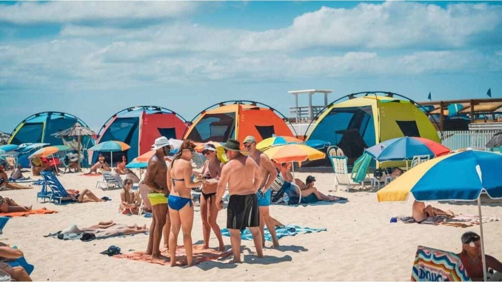 Canicule en plein mois d’août : des vacanciers enragés s’en prennent violemment aux tentes climatisées plantées sur la plage et hurlent « vous nous laissez crever au soleil pendant que vous vivez dans un congélateur privé » sous les regards terrifiés des familles avec enfants tandis que des associations dénoncent « un scandale écologique inacceptable » et que d’autres assurent au contraire « c’est la seule façon de survivre en août 2025 dans ce pays devenu fournaise »